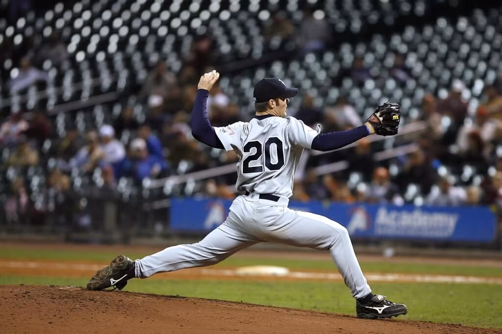 A baseball pitcher throwing a pitch during a World Series game under stadium lights.
