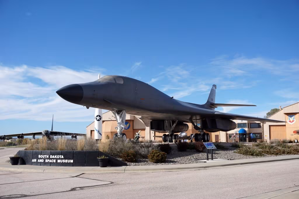 A black and white image of a large strategic bomber aircraft taking off from a military base.