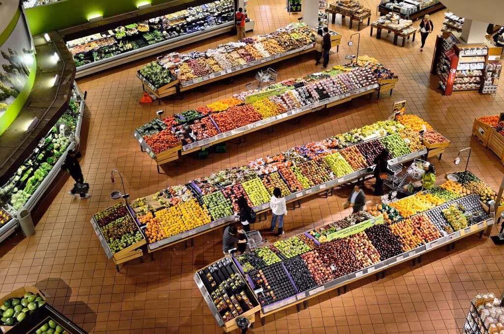 A comparison shot showing fresh fruits and vegetables next to shelves stocked with processed, packaged foods.