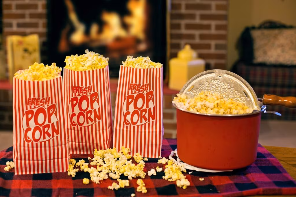 A dedicated air popcorn popper machine actively popping corn kernels into a bowl in a modern kitchen.