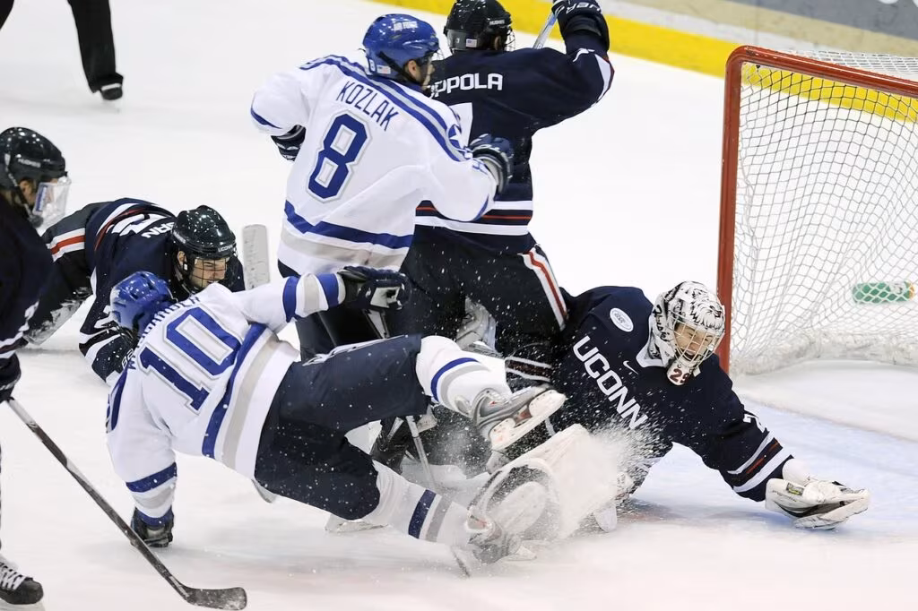 A hockey goalie making a dramatic save during a fast-paced game.