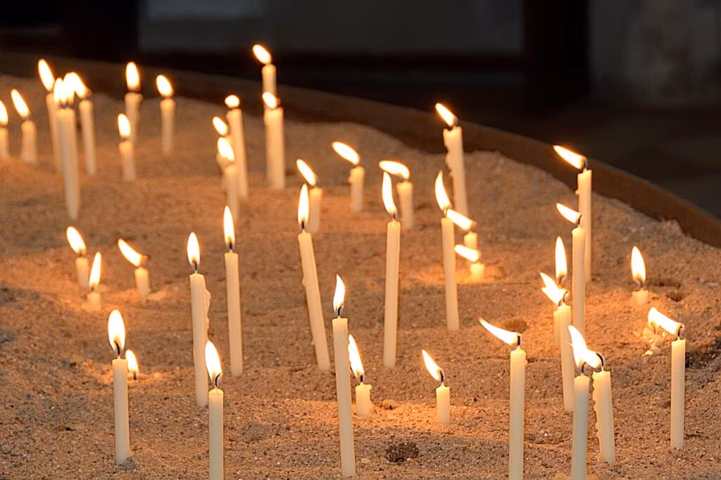 Candles lit during a vigil, representing community mourning and the call for justice following the death of Sonya Massey.