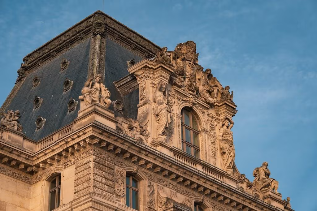 Exterior view of the Louvre Museum in Paris with police tape and security personnel visible