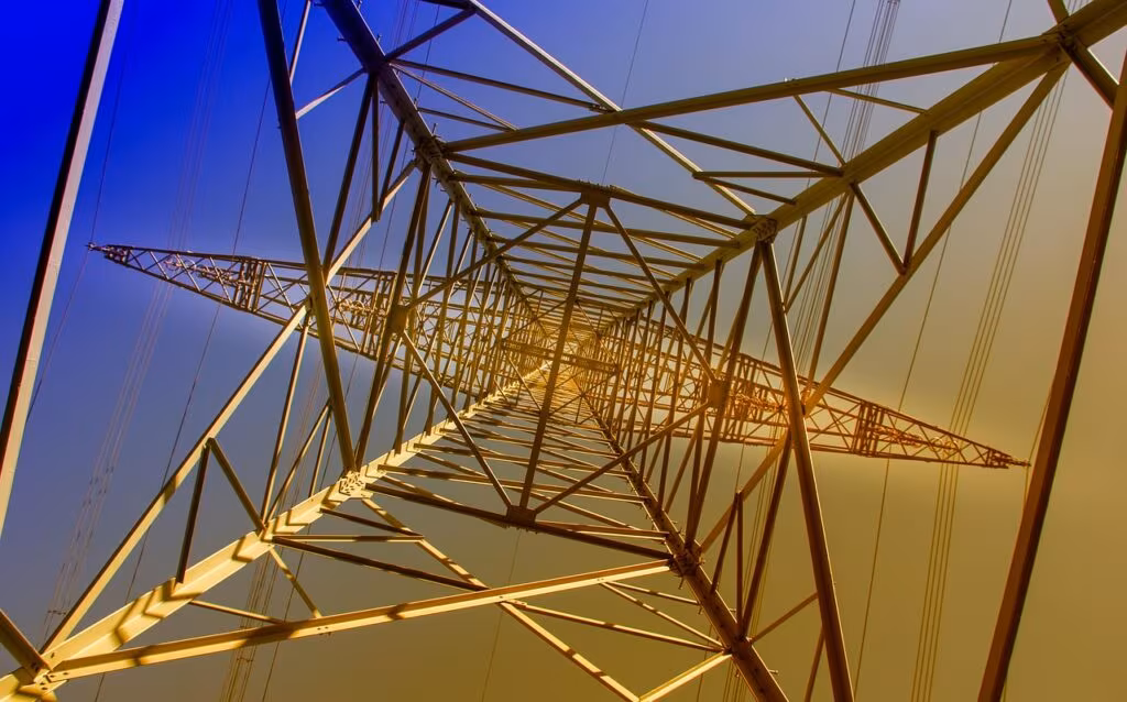 Large industrial Bitcoin mining facility with rows of containers and high-voltage power lines in the background.