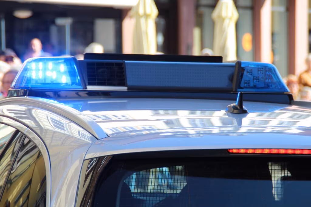 Law enforcement vehicles with flashing lights responding to a security threat in a residential area.