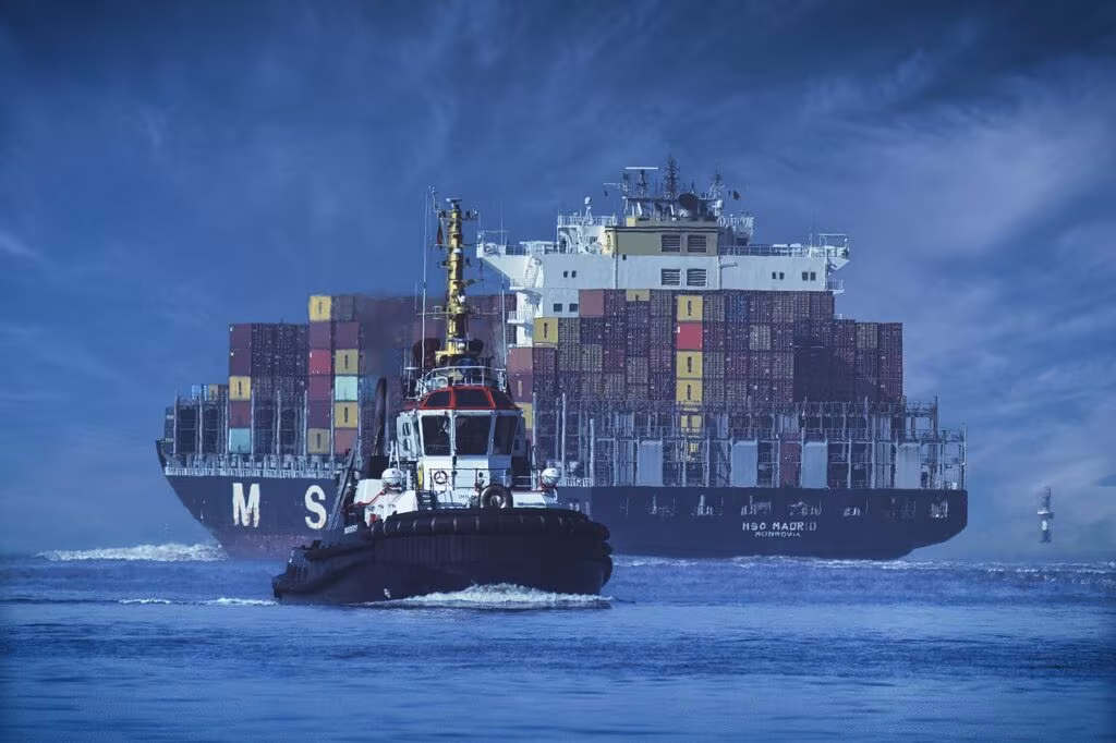 Shipping containers stacked high near a port with a blurred global trade map in the background, symbolizing tariffs and trade policy.