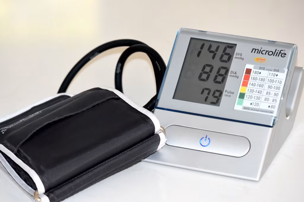 A digital blood pressure cuff connected to a tablet displaying health data, representing remote patient monitoring.