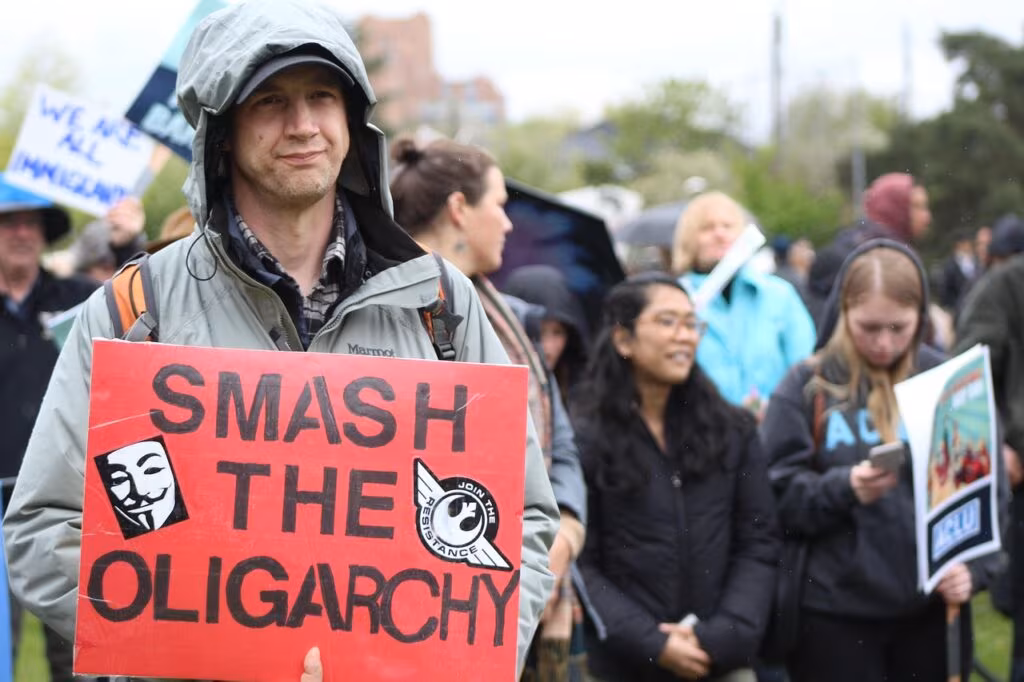 A large crowd at a political rally with American flags, symbolizing the intense primary competition for the Republican nomination in GA-14.