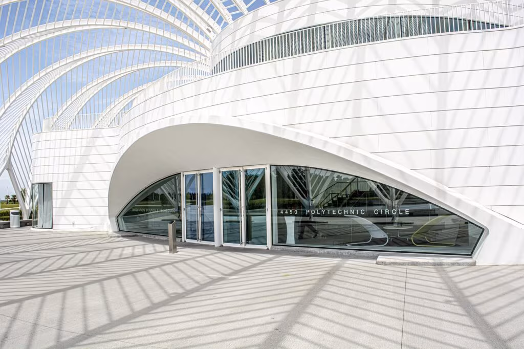 A minimalist, futuristic white sneaker prototype on a clean display stand.