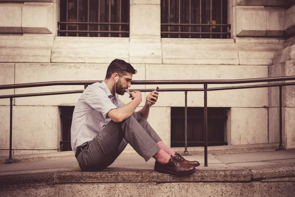 A person sitting calmly, looking at their phone with a relaxed expression, symbolizing reduced digital stress.