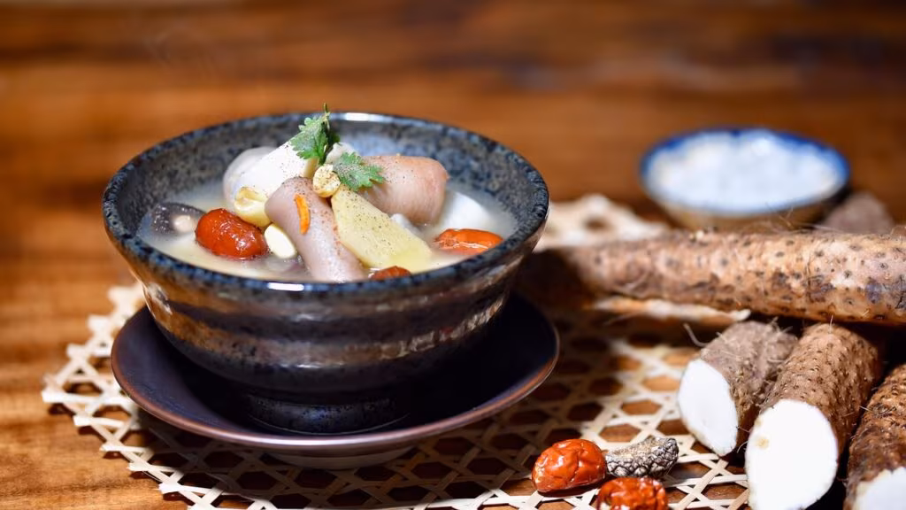 A simple bowl of rice next to a bowl of vegetable soup, representing a traditional Chinese diet.