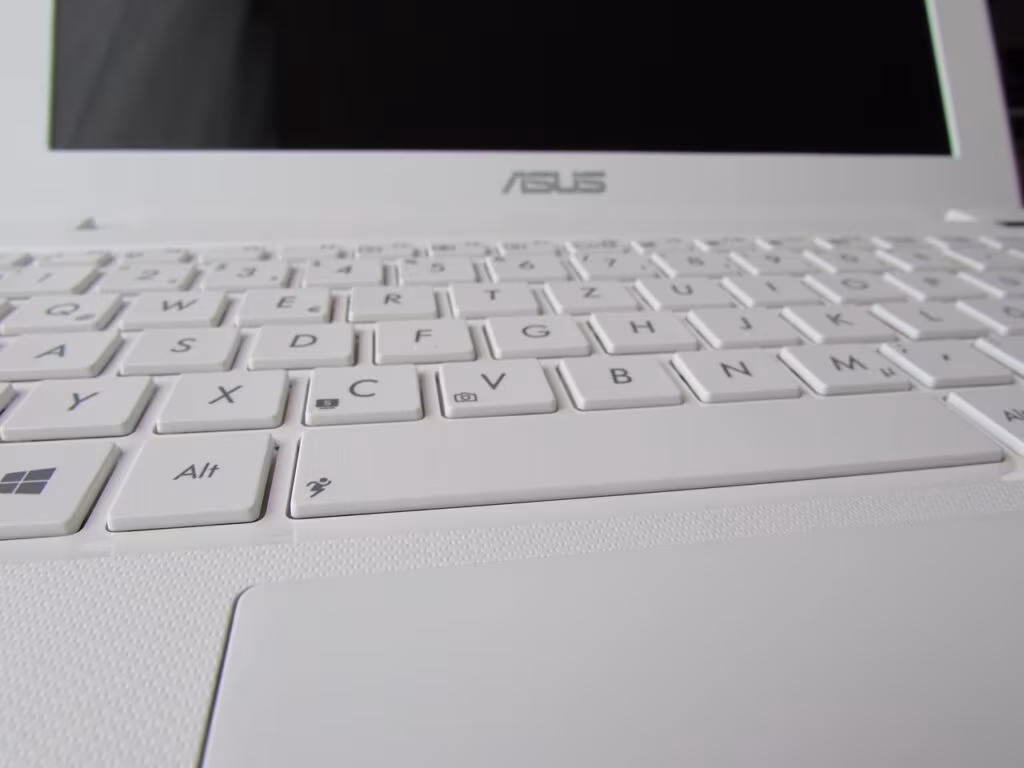 A small, white netbook computer from the late 2000s next to a modern tablet, illustrating the size difference.