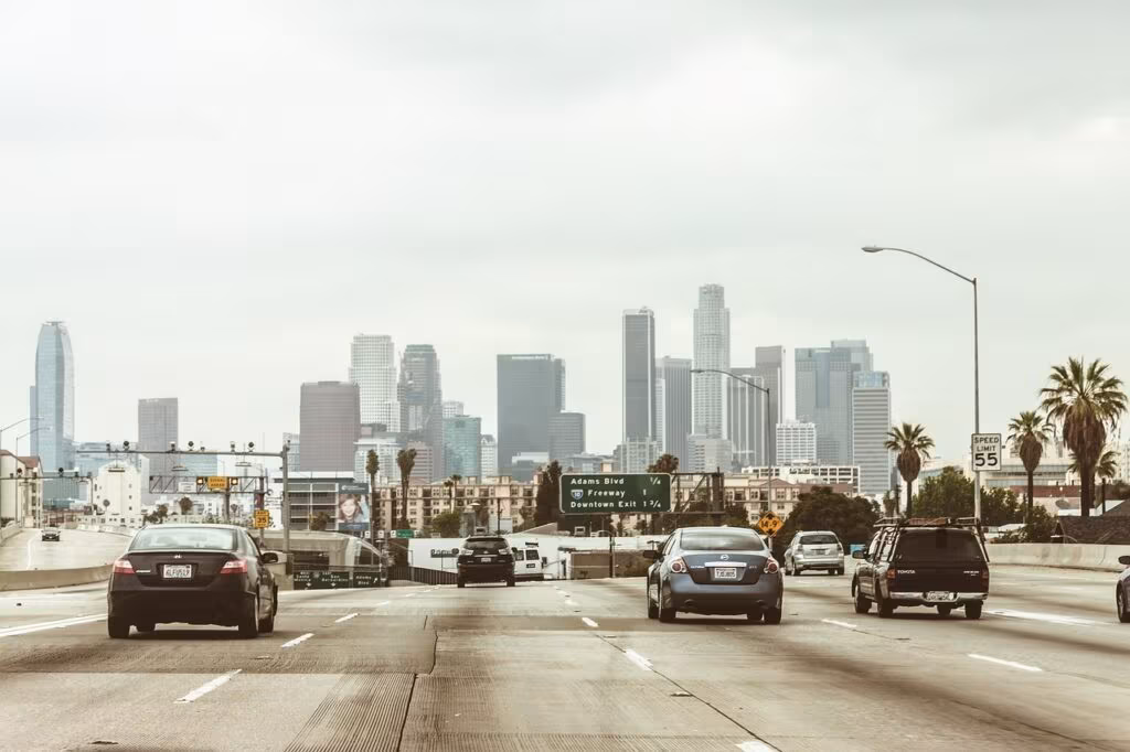 Aerial view of the sprawling Los Angeles downtown skyline with heavy freeway traffic