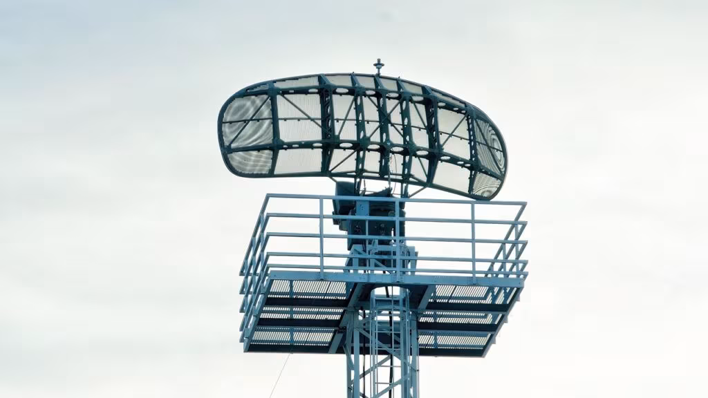 Air traffic controller monitoring radar screens in a dimly lit control center