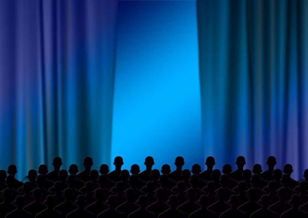 Audience watching a film in a dark movie theater, focusing on the screen.