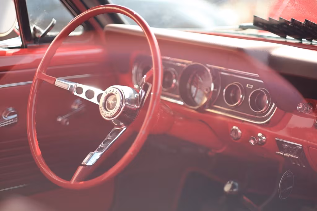 Close-up of the iconic chrome running pony emblem on a classic Ford Mustang grille
