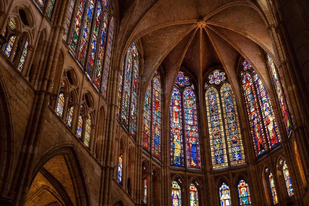 Dark, gothic church interior with light streaming through stained glass, symbolizing religious horror