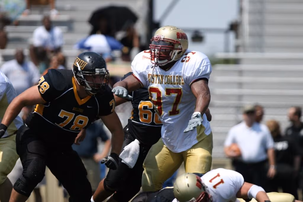 Defensive lineman tackling a running back during a college football game