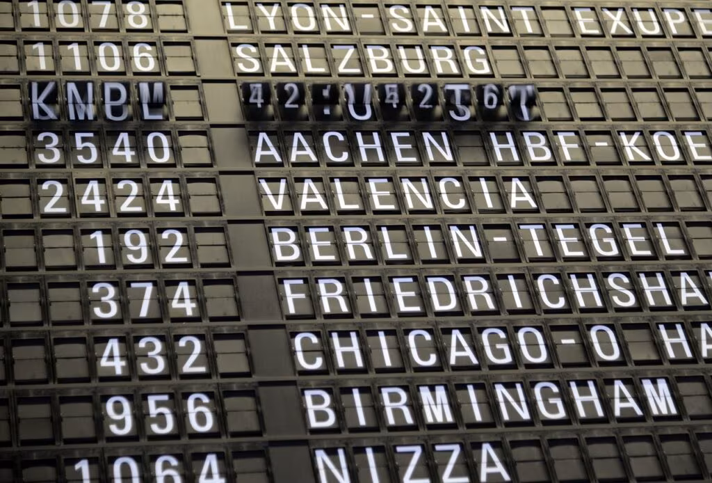Digital departure board at an airport showing multiple flights marked as delayed