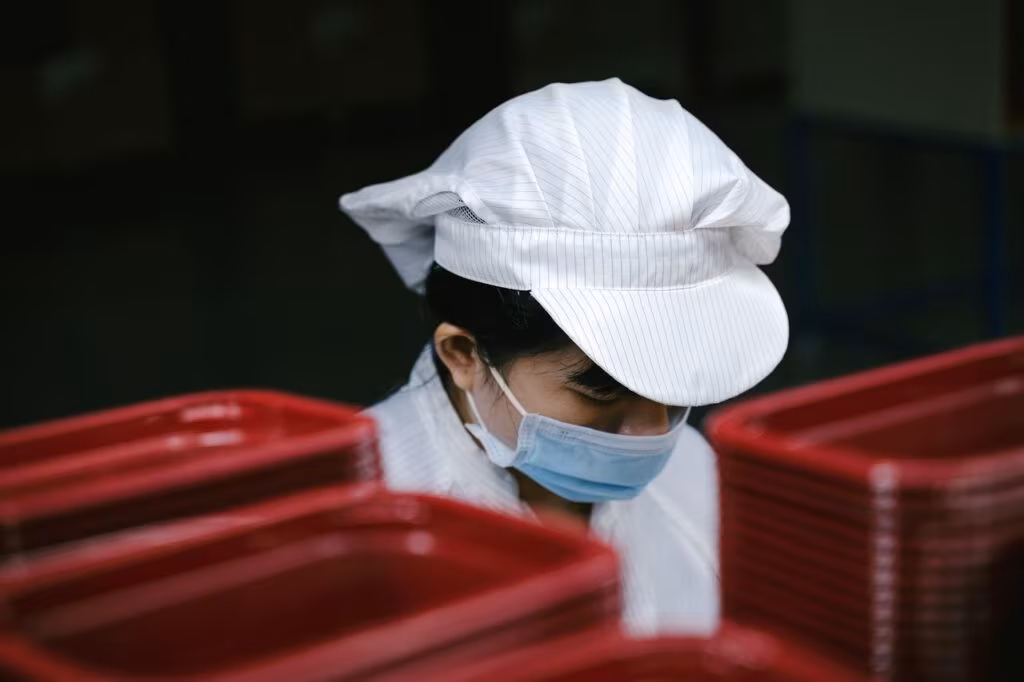 Engineers working in a semiconductor clean room with advanced machinery