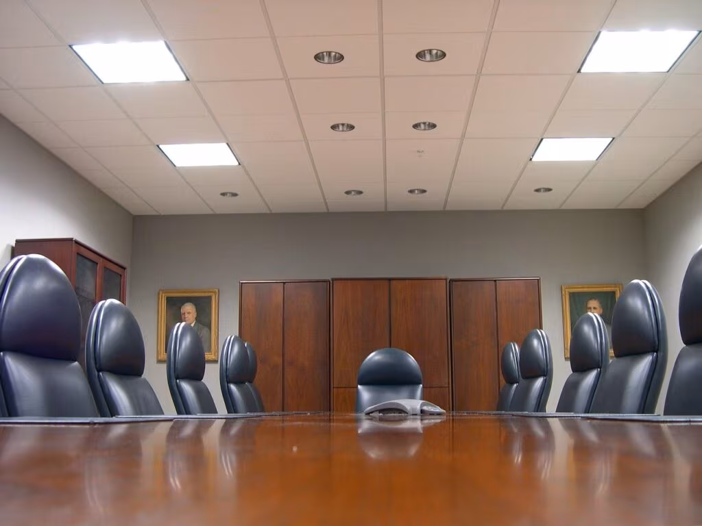 Executives in a modern boardroom discussing financial data and risk management strategies on a large screen during a market crisis.