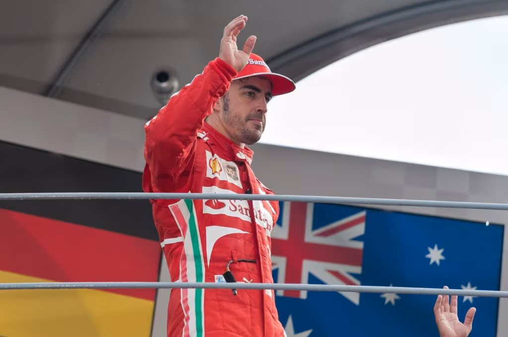 Formula 1 drivers celebrating on the podium with champagne after a successful race.