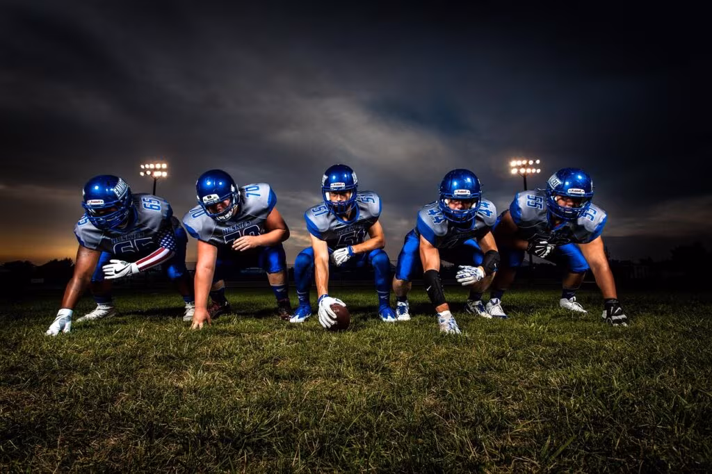Intense action between two rival American football teams in a packed stadium with cheering fans.
