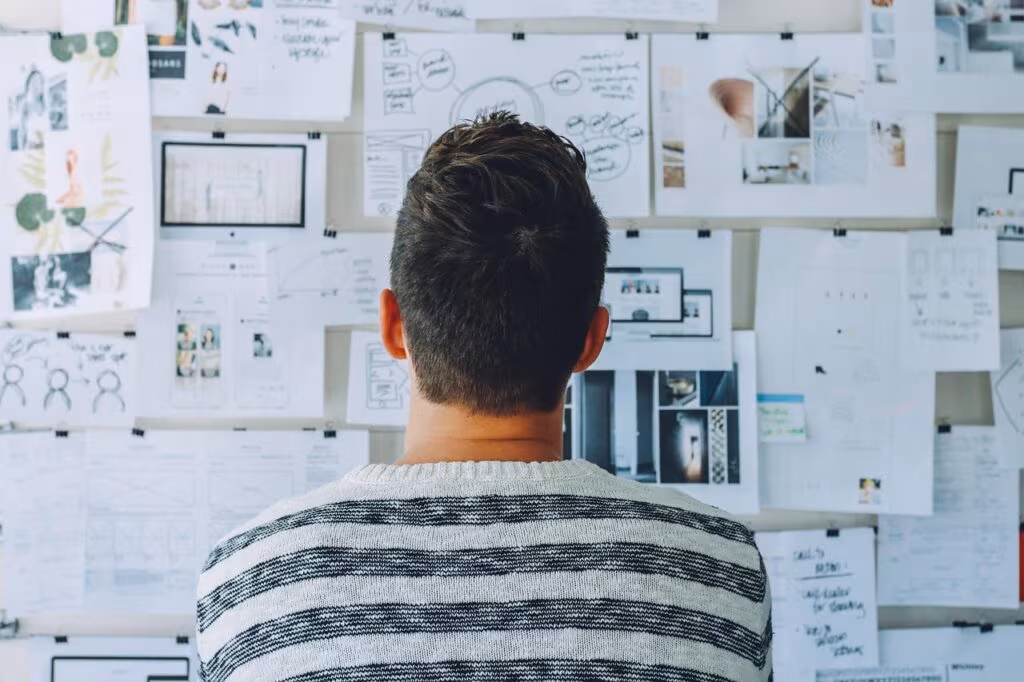 Marketing professionals discussing strategy and planning on a whiteboard in a modern office.