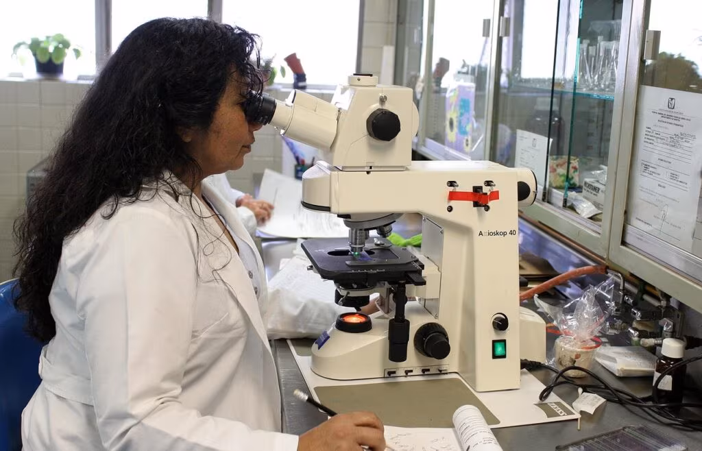 Scientist in a laboratory examining an ice core sample used for paleoclimate research.